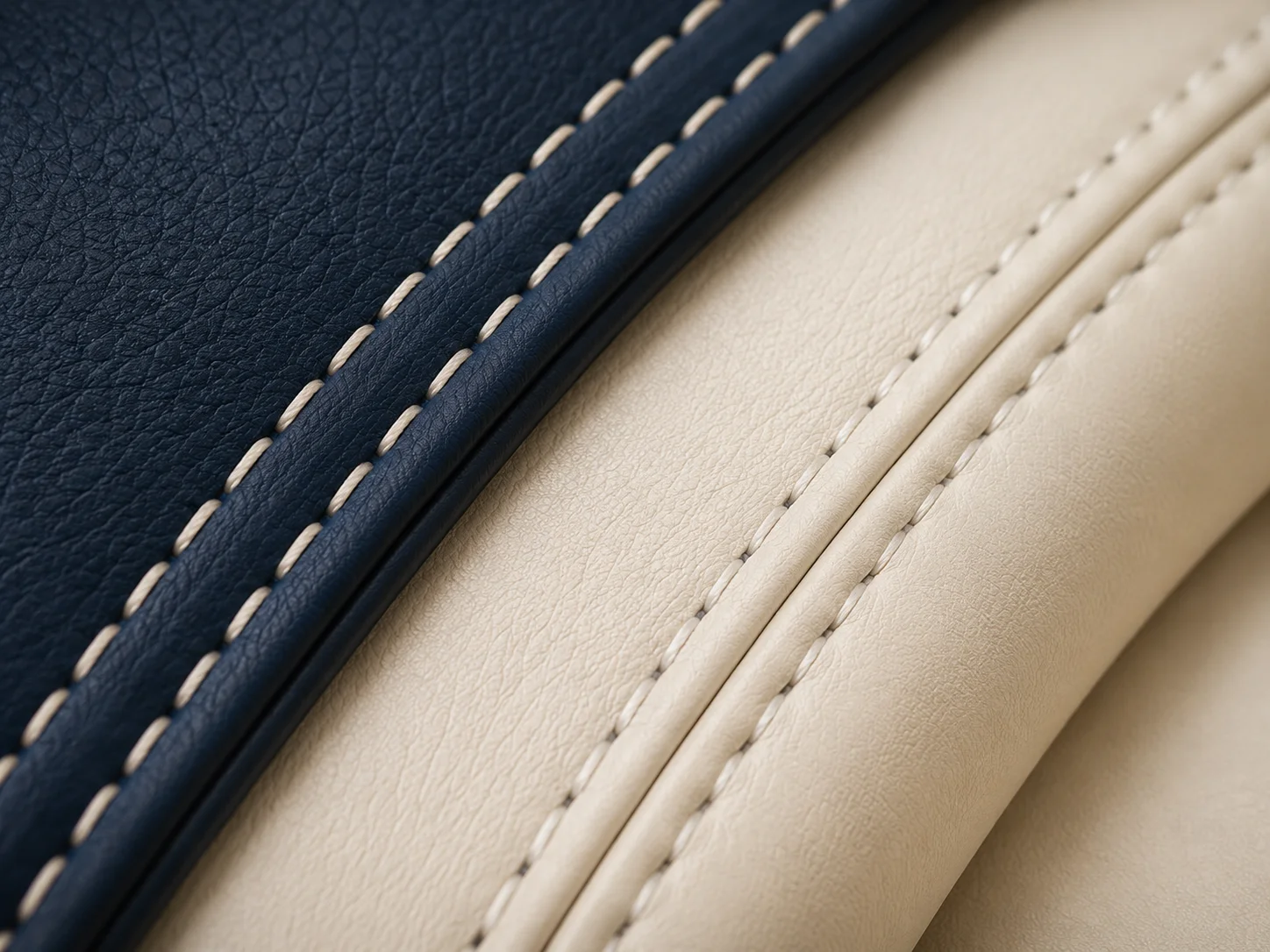 Macro sur une couture de sellerie bleu marine et ivoire