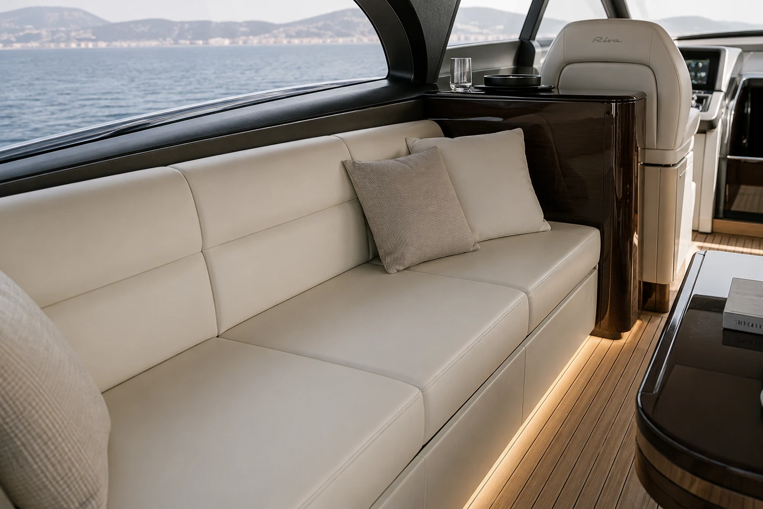 Banquette de carré intérieur en cuir crème avec coussins, à bord d'un bateau à moteur